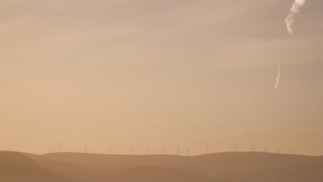 Golden-sunrise-over-wind-turbines-in-a-rural-area-of-Scotland-in-winter-in-Perth-Shire,-United-Kingdom