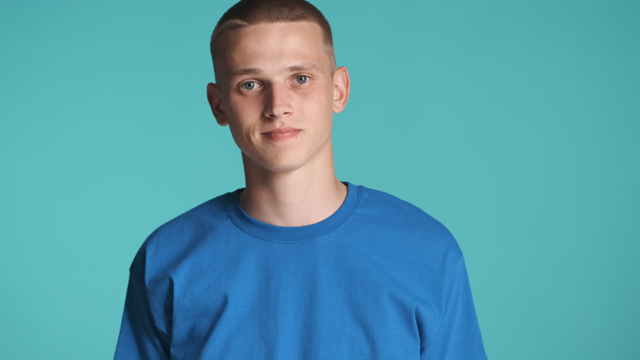 파란 옷을 입은 의심스러운 소년이 포즈를 취하고 있습니다.