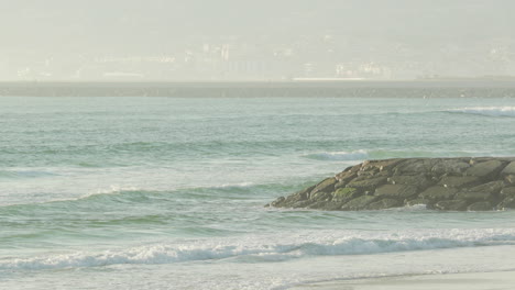 beautiful calm waves rolling to the beach of figueira da foz in portugal -wide