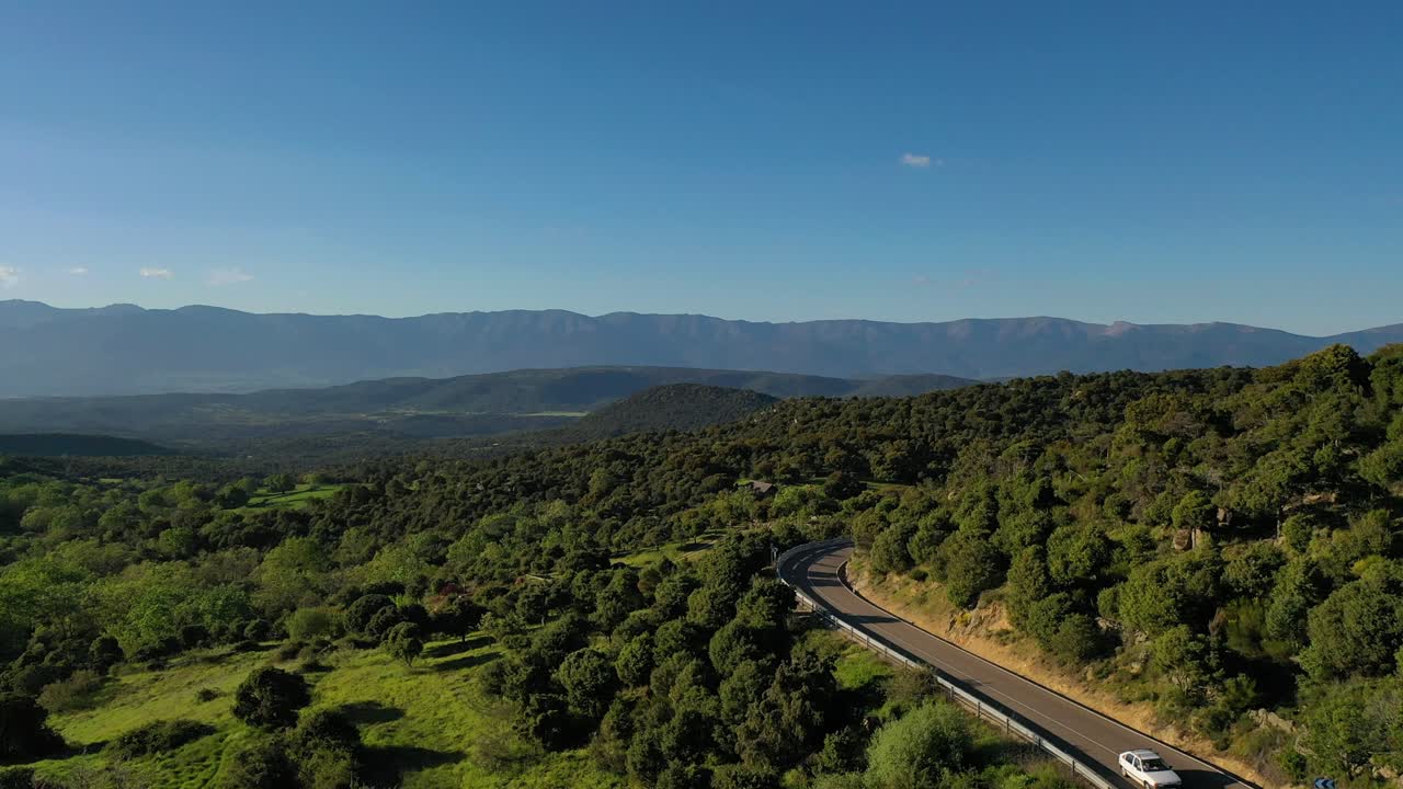 vuelo de avión no tripulado en el valle de tietar viendo en la distancia el sistema de montañas continuas y un gran bosque de pinos, robles, robles y enebros mezclados más cerca juntos vemos una carretera con coches conduciendo