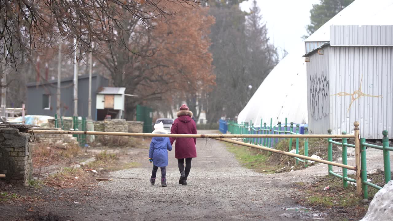 나무가 있는 골목 끝을 향해 안개 속에서 걸어가는 사람들. 대도시의 신비한 분위기