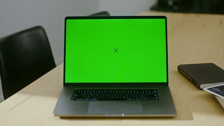 Ein offener Laptop mit Greenscreen steht auf dem Schreibtisch des Architekten