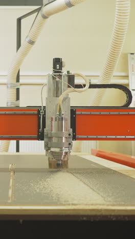 wood lathe machine cuts out simple plywood details in woodwork shop closeup. cutting tool with small drill processes material at carpentry slow motion