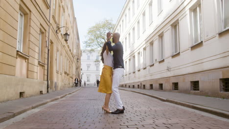 happy interracial couple dancing bachata in the old town street 2