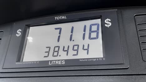 gas price screen in dollars on fuel pump increasing based on litres, close up