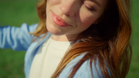 closeup pretty woman face smiling to spring world on green grass background.