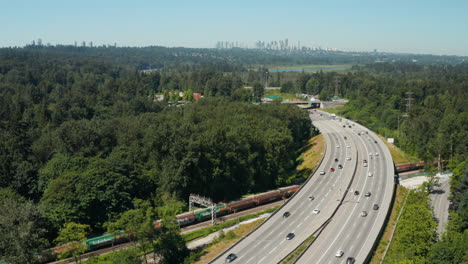 Vista-Aérea-Sobre-La-Autopista-Transcanadiense-A-Través-De-Burnaby-Con-El-Horizonte-Del-Centro-De-Vancouver-En-La-Distancia