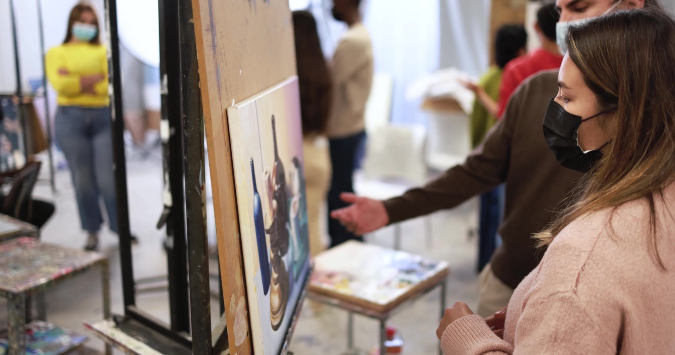 Studenti d'arte che discutono un dipinto in un'aula studio