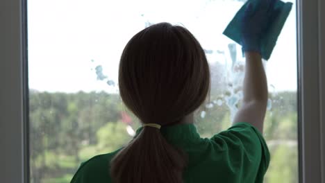 cleaning company worker or housewife cleaning windows using detergent and window cleaning cloth. washing windows with a spray bottle.