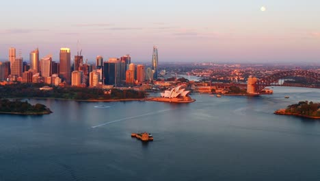 distant aerial view of sydney harbour with opera house in the center during sunrise, nsw australia