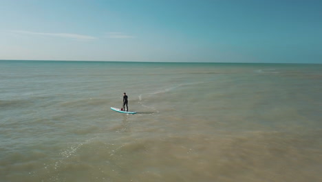 Drone-Círculos-Joven-Stand-Up-Paddle-Surf-En-El-Mar-Con-Acantilados-Blancos-De-Dover-En-El-Fondo