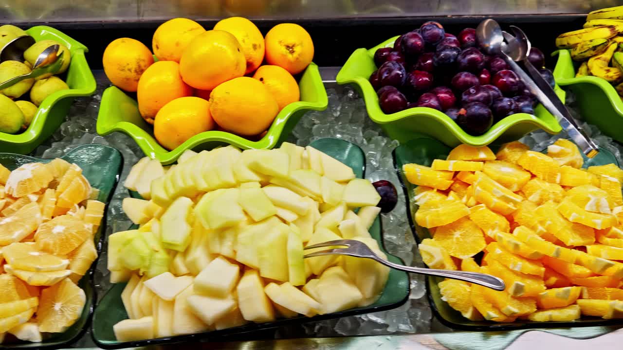 Fresh fruit buffet display in bowls over ice. Oranges, apples, mangoes, bananas
