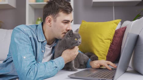 Mann-Und-Katze-Schauen-Gemeinsam-Auf-Den-Laptop.