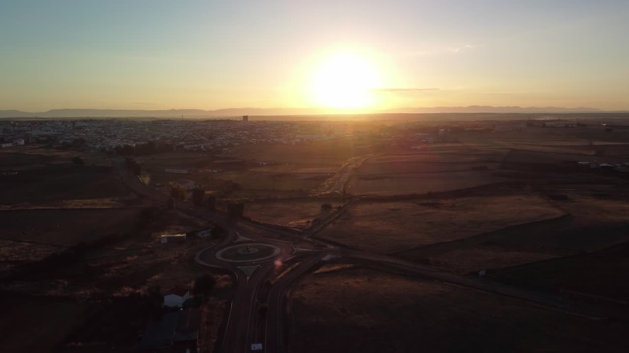 ciudad de pozoblanco al amanecer con cielo despejado y una rotonda visible, vista aérea