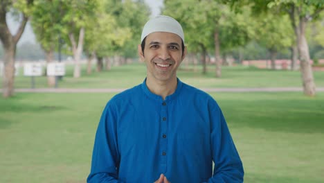 happy muslim man talking to the camera in park