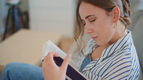 Mujer-Enfocada-Leyendo-Un-Libro-En-El-Sofá