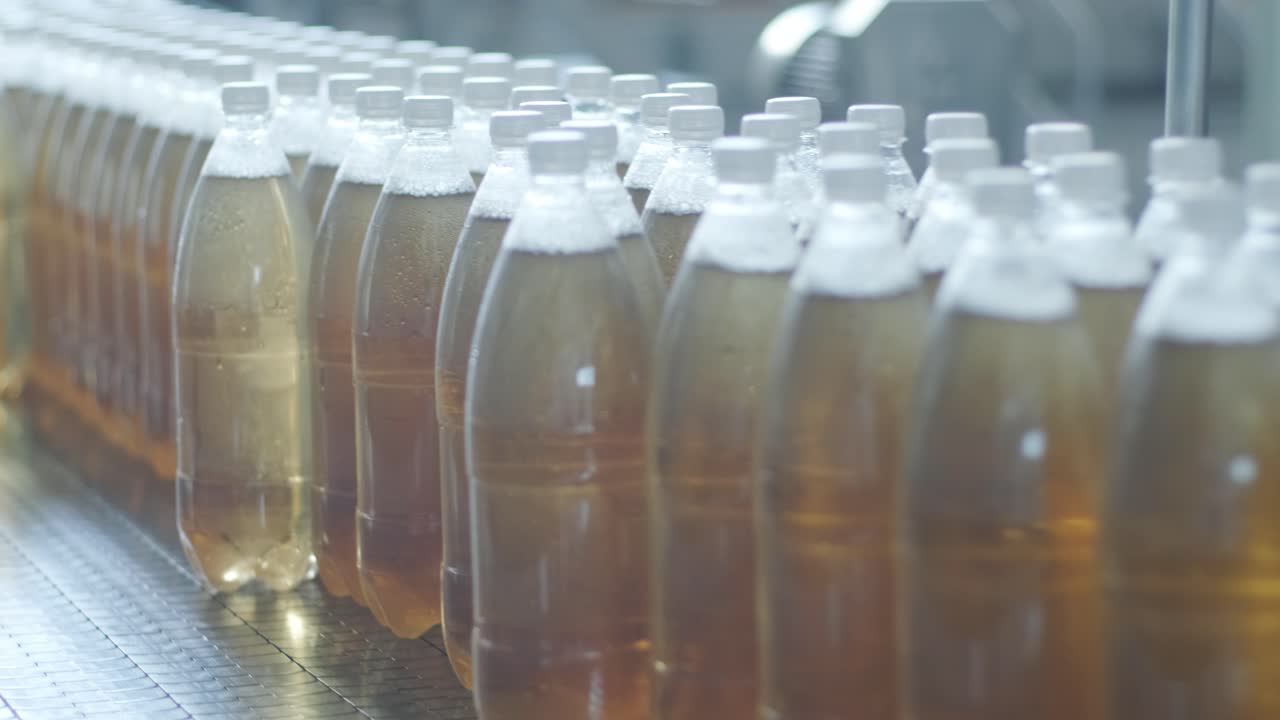 현대 음료 공장에서 주스 또는 물을위한 병을 가진 컨베이어 벨트 - 달한 소다 물의 현대 생산