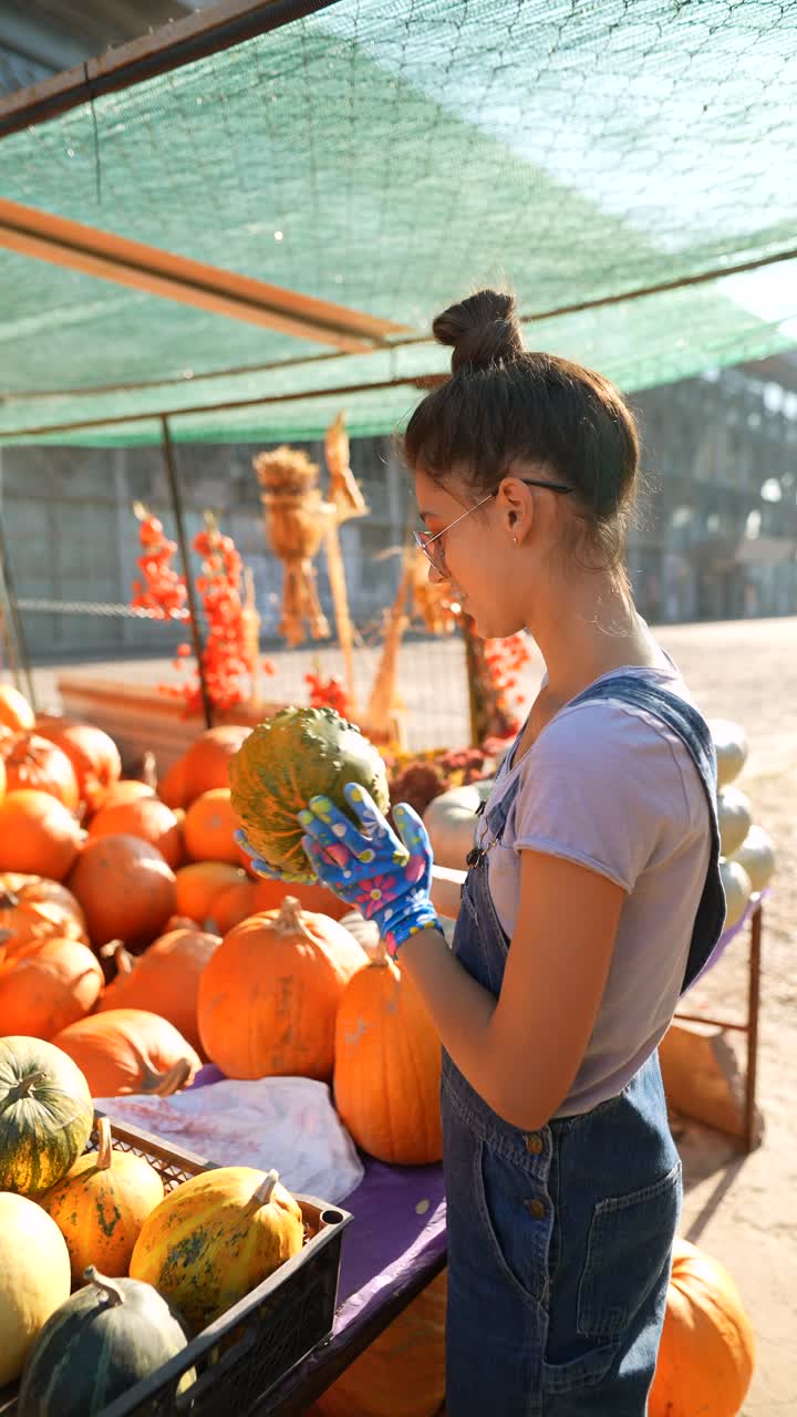 한 여자 가 가을 시장 에서 호박 을 구입 하고 있다
