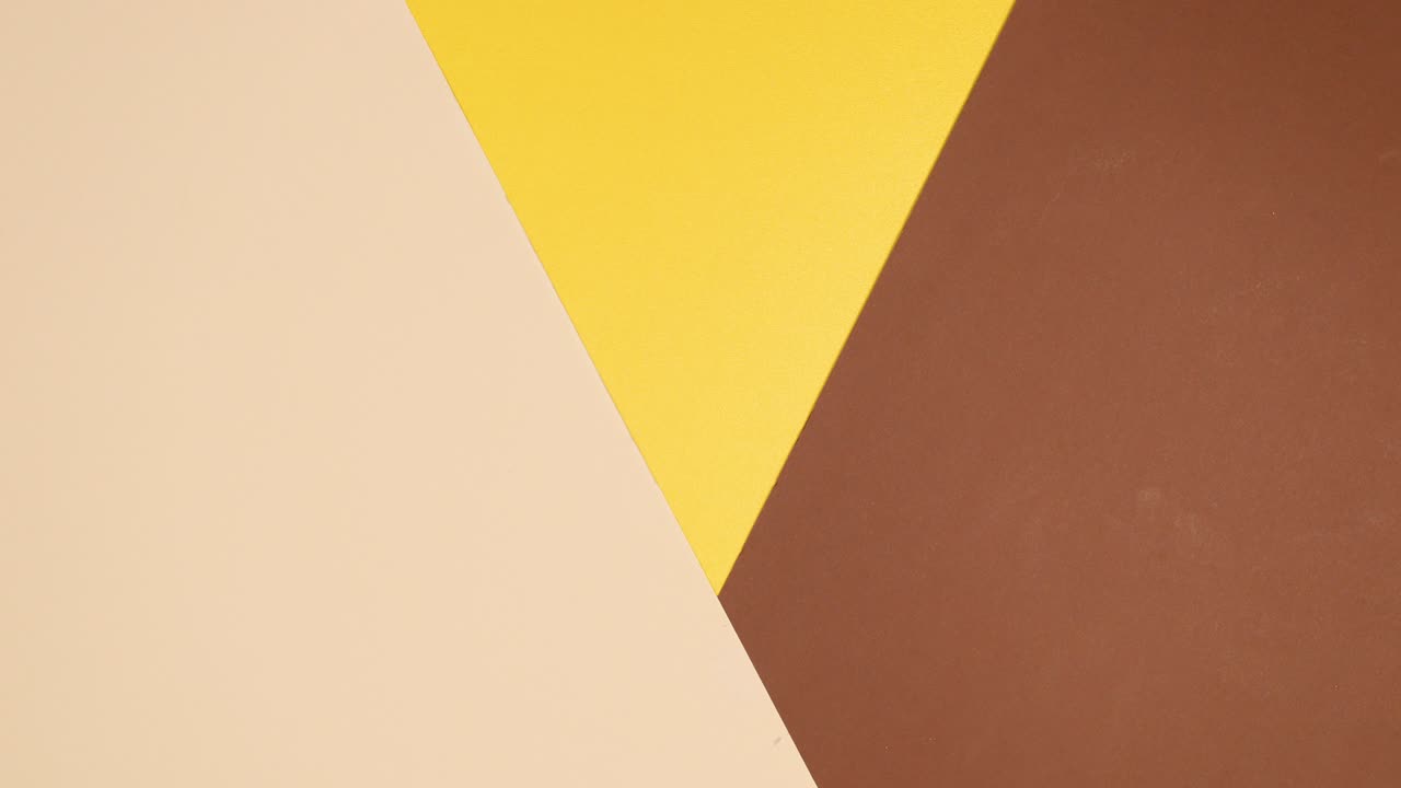 Golden tropic leaves appear on gold nude background. Stop motion flat lay exotic concept