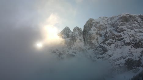 Fliegen-Zwischen-Wolken-Mit-Blick-Auf-Schneebedeckte-Berge-Und-Sonnenstrahlen