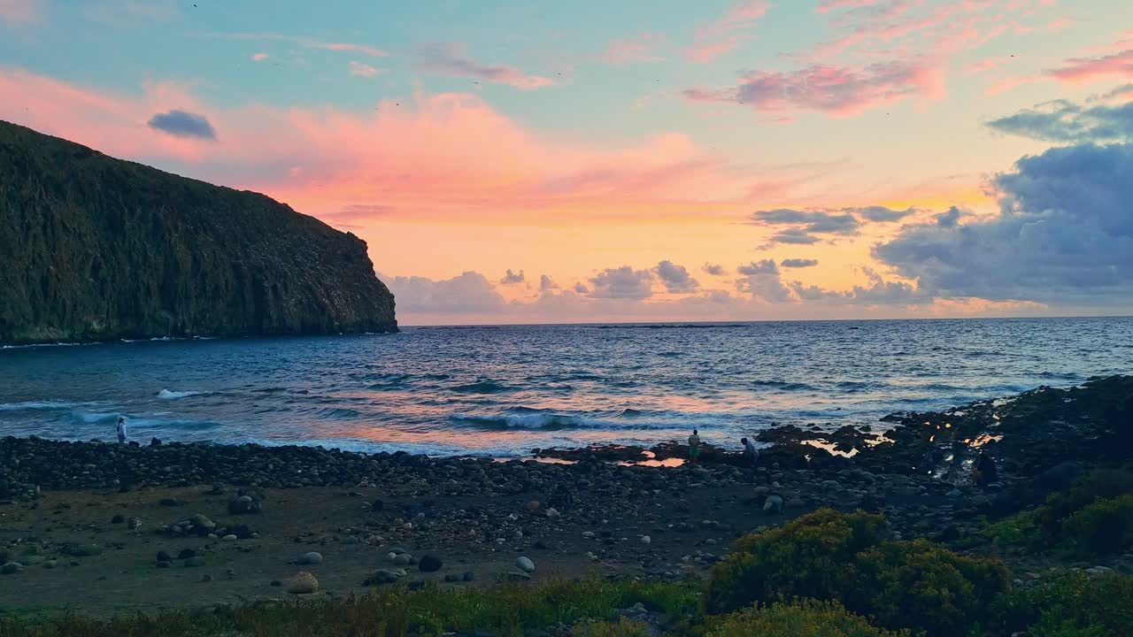 일몰 시간에 아름다운 잔잔한 바다와 바위 언덕을 즐기는 사람들, 스페인