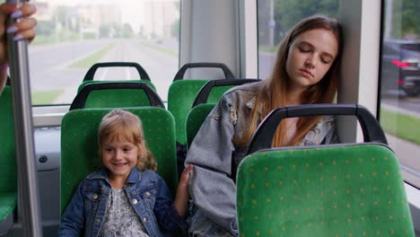 Erschöpfte-Mutter-Schläft-Ein-Und-Verpasst-Haltestelle-In-Der-Straßenbahn,-Kind-Tochter-Wacht-Müde-Schläfrige-Frau-Auf