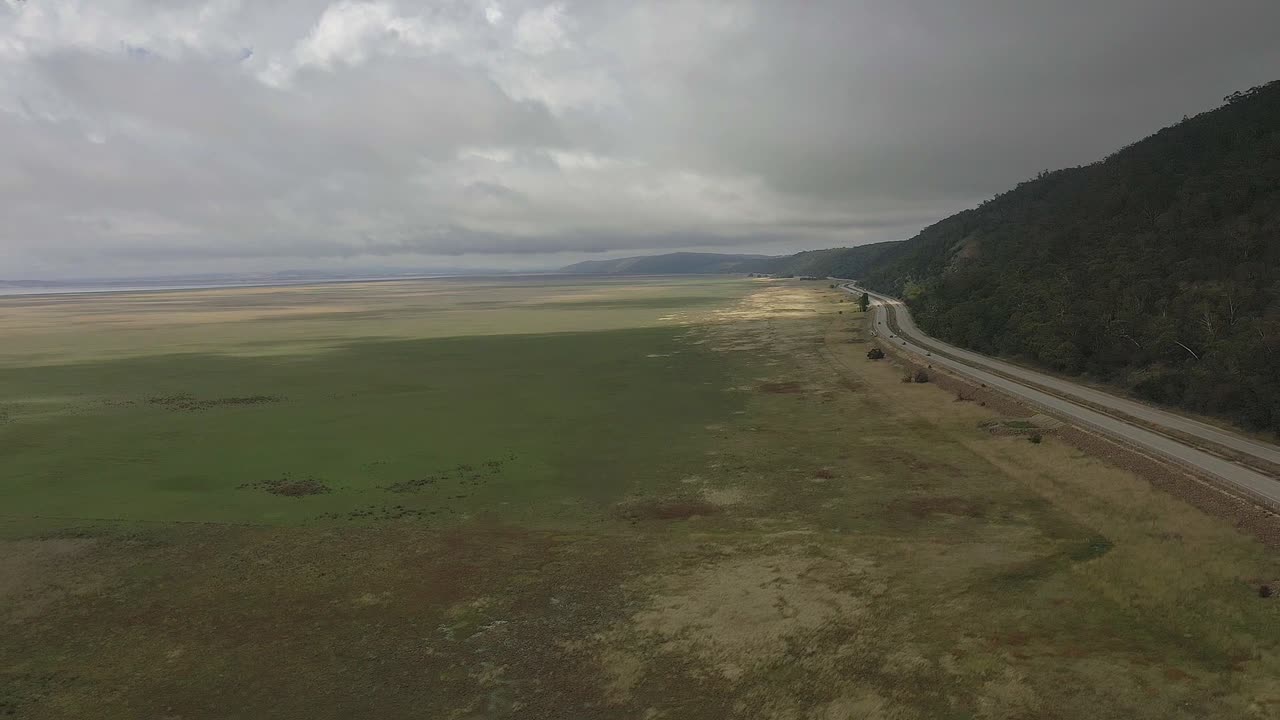 Aerial POV moving backward along busy highway