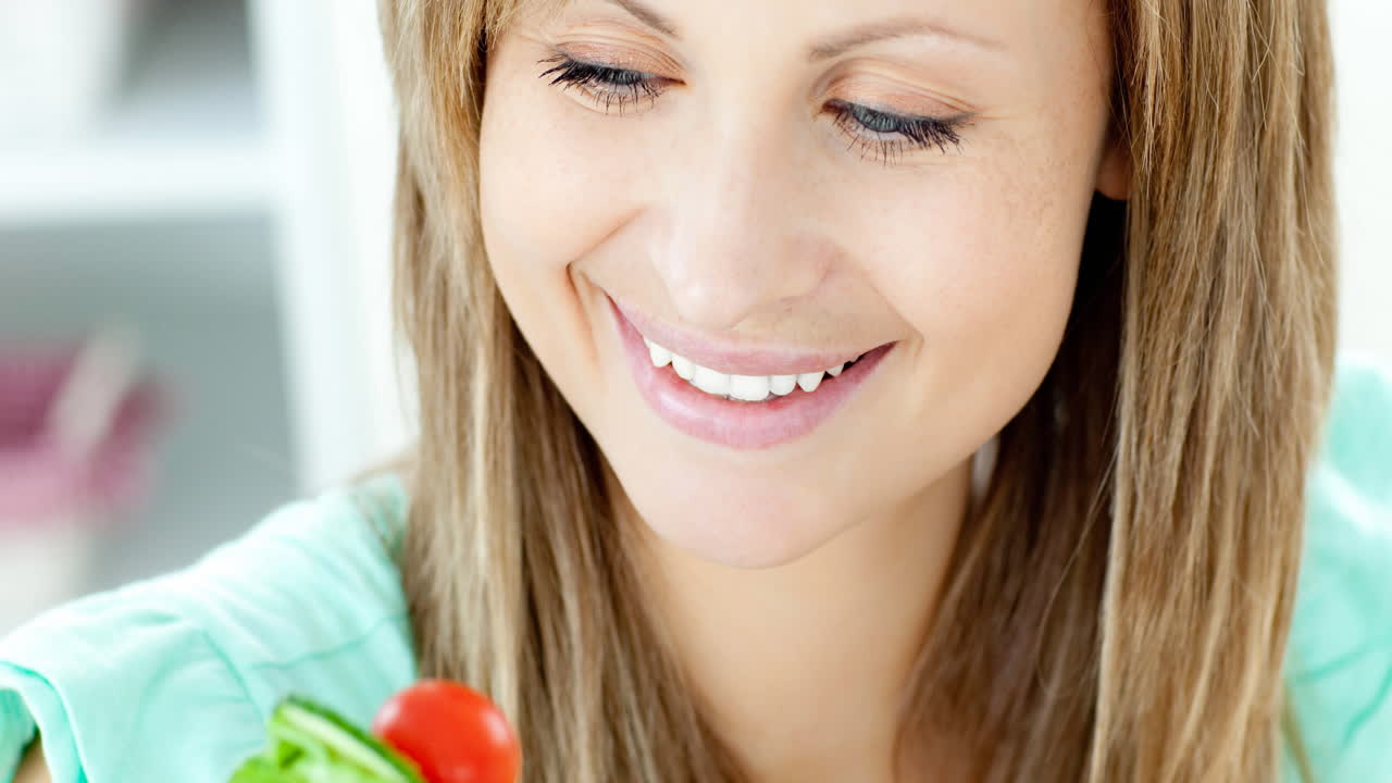Animação de mulher caucasiana comendo salada de vegetais na cozinha
