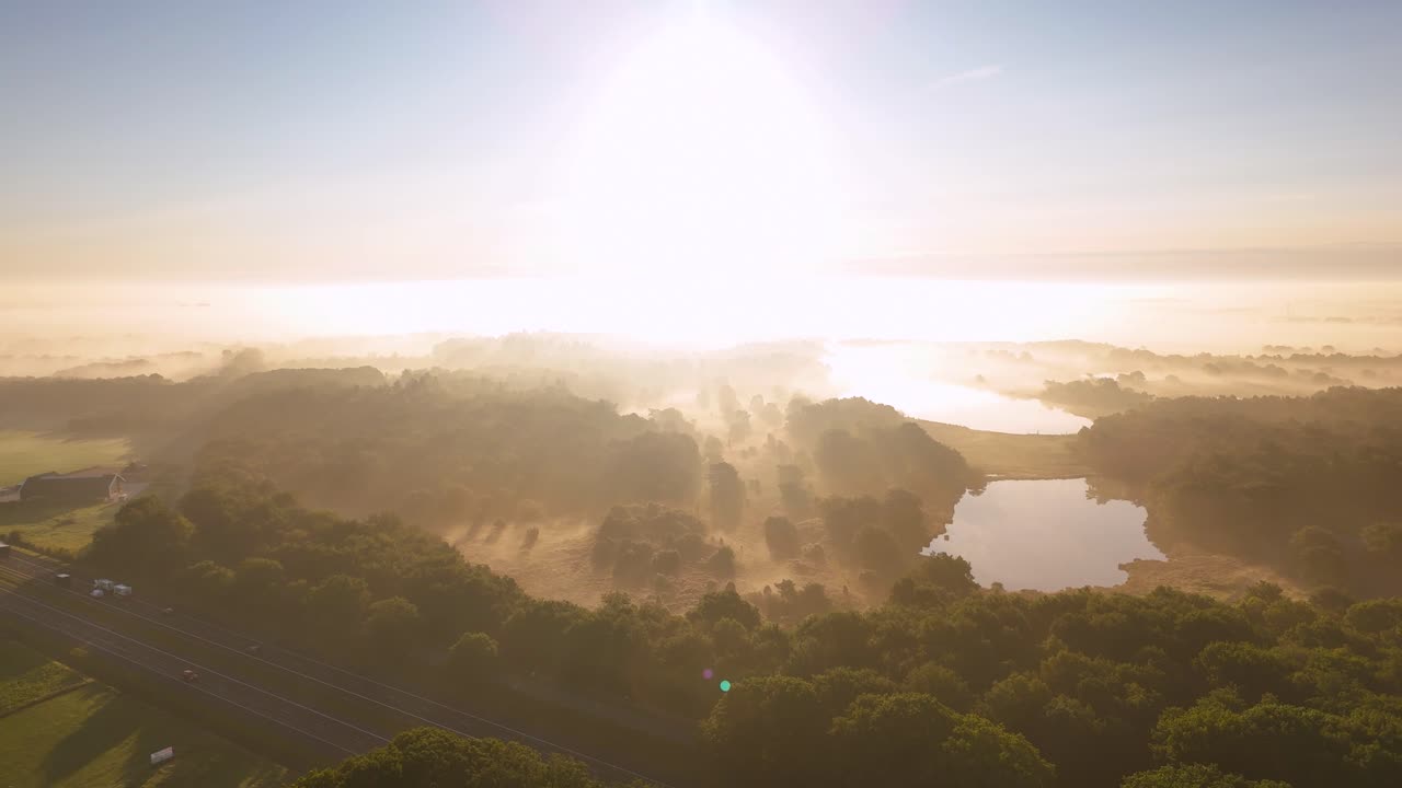 Aerial View of Misty Forest and Lakes at Sunrise with Highway