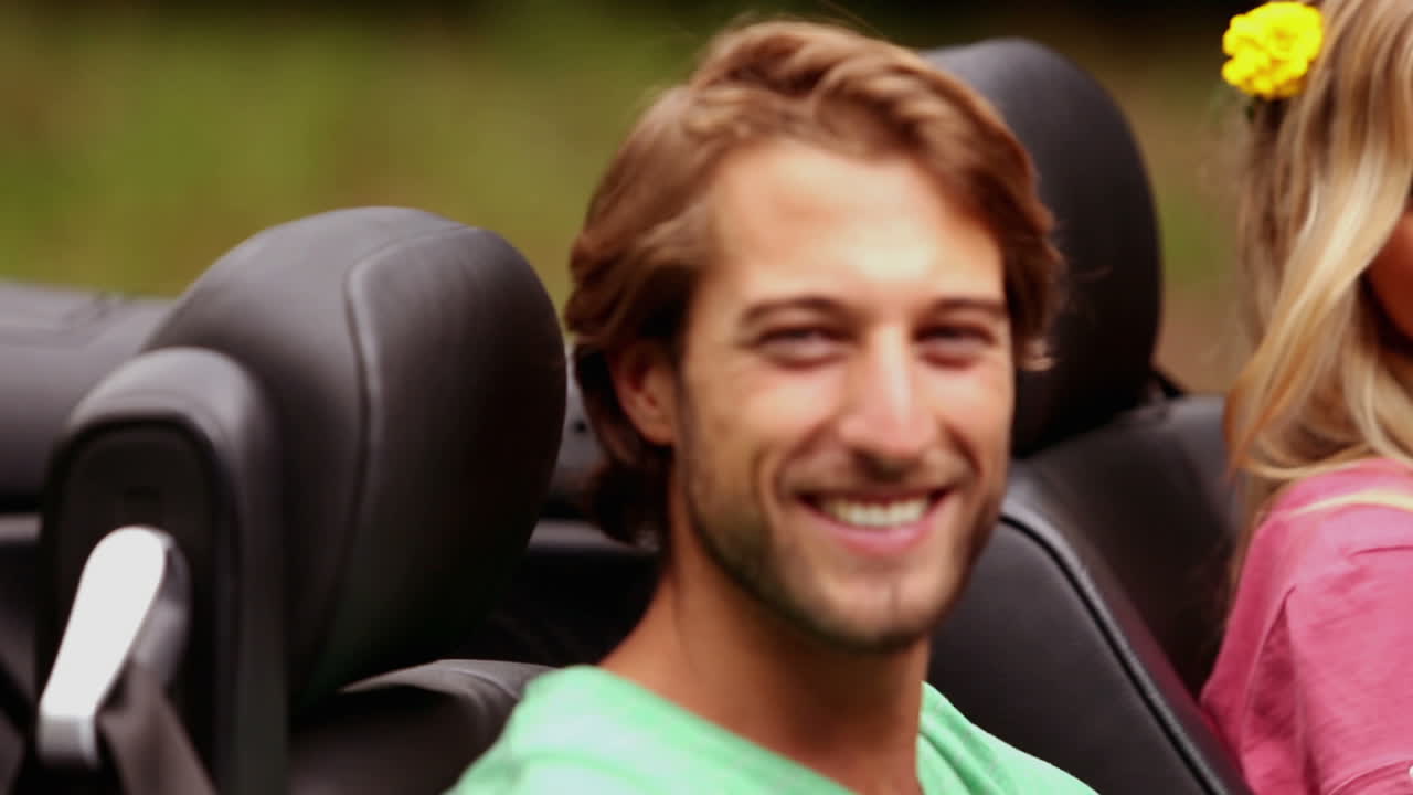 una pareja en un coche plateado.