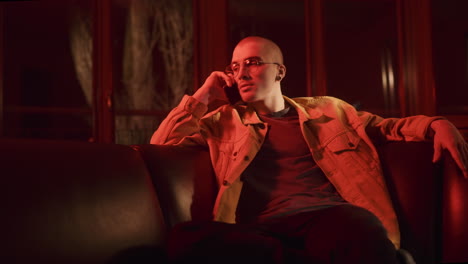 young man on a couch talking on phone