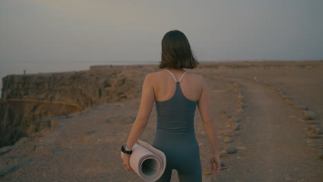 woman practicing yoga outdoors at sunset