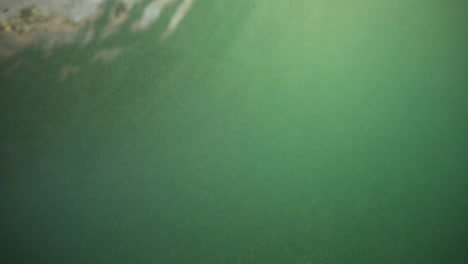 the camera is submerged beneath the water's surface, capturing the clear, dynamic movement of ocean waves. the light filters through the water, creating mesmerizing patterns as the waves ebb and flow