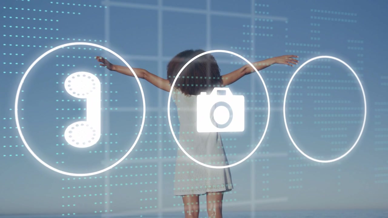 Woman lifting and sweeping arms on beach as glowing icon appears, activating tech icons and grid