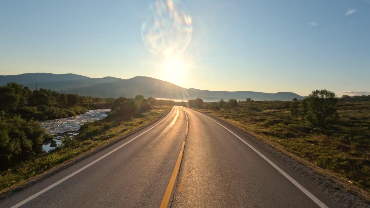 conduciendo un coche en una carretera de noruega al amanecer.