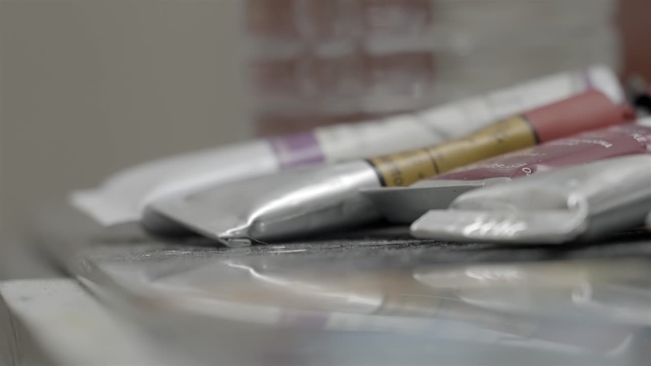 Primo piano macro di tubetti di pittura a olio usati sul tavolo dello studio di un artista.