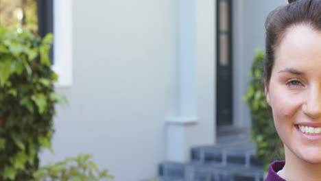 Half-face-of-happy-caucasian-woman-standing-and-smiling-in-sunny-garden