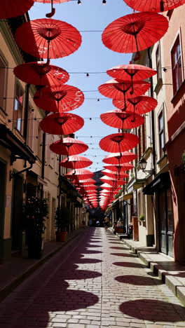 red umbrellas decorate a charming european alley