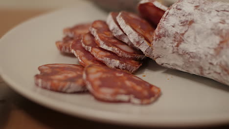 Acerque-Lentamente-Las-Lonchas-De-Chorizo-Español-En-Un-Plato-Blanco