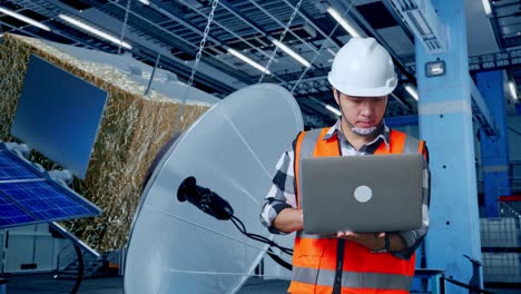 técnico de satélites trabajando en una computadora portátil en una instalación