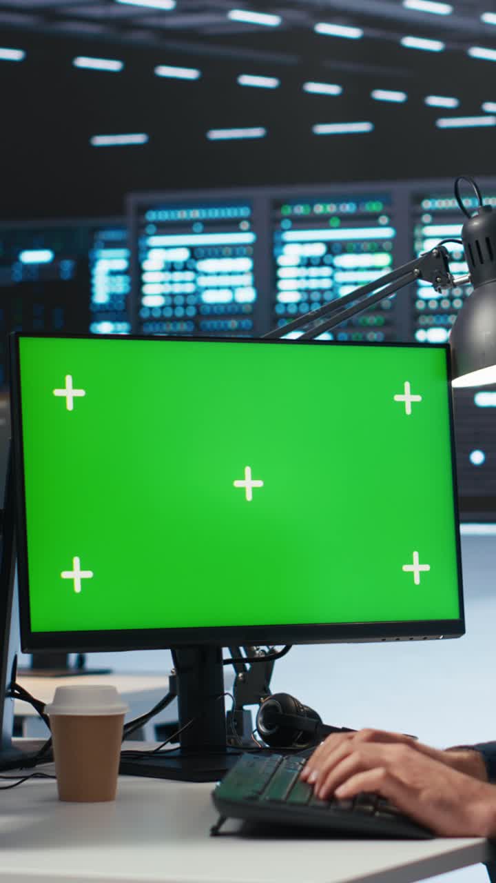 Hænder der skriver på tastatur med grøn skærm i datacenter