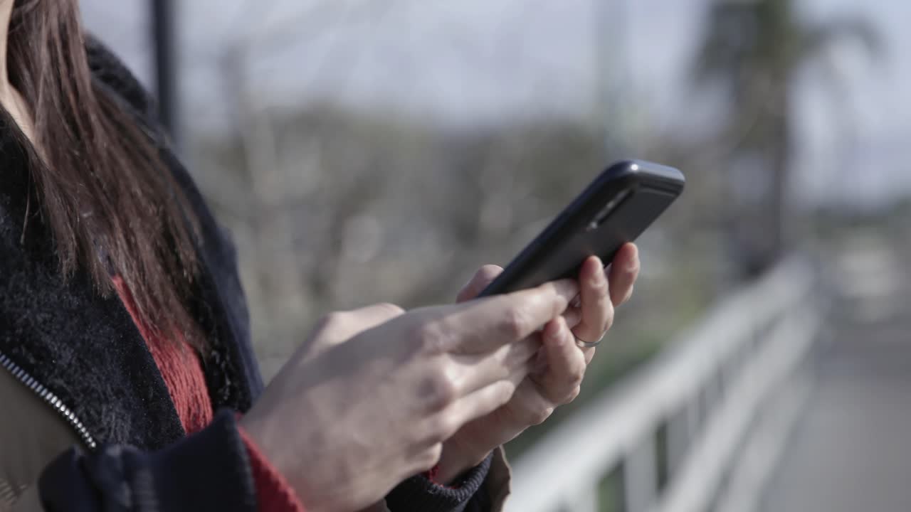 Close-up of Person's Hands Using Smartphone Outdoors
