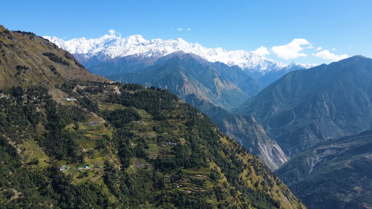 Aerial drone shot capturing the charm of a small village with terraced fields in the high-altitude mountains.