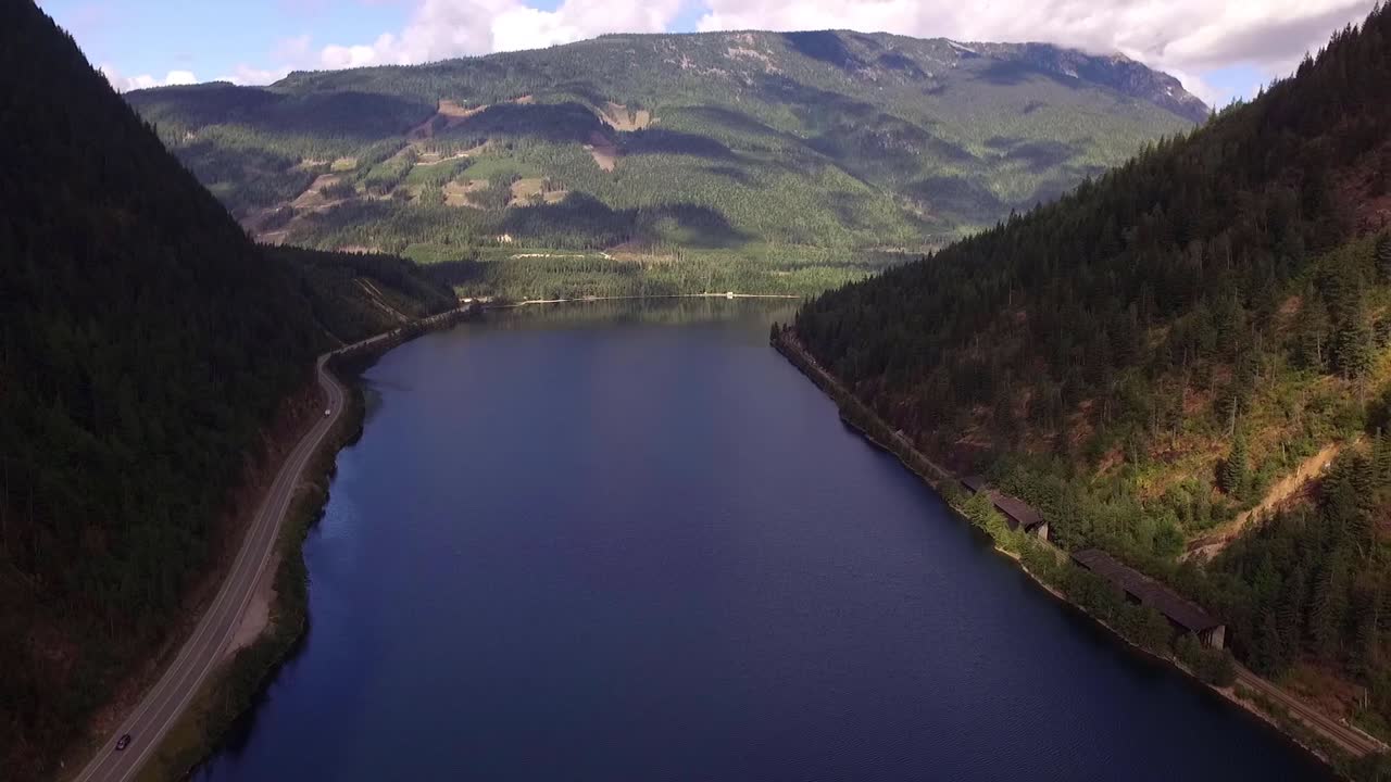 Aerial View of a Serene Lake Surrounded by Mountains and Forest