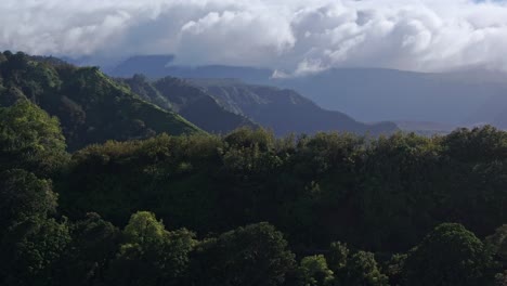 Beautiful-lush-green-tropical-ridges-and-valleys-with-swirling-clouds-in-sky-above-north-shore-of-Maui