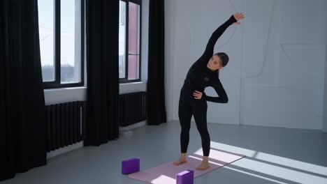 mujer estirándose en un estudio de yoga