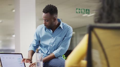 video of focused african american businessman talking in office with female colleague