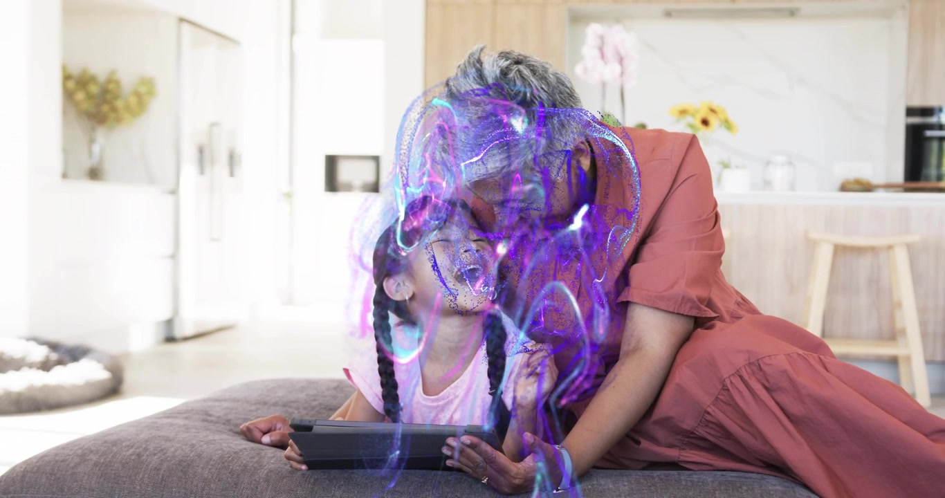 Grandmother guiding granddaughter tapping tablet in open home, causing glowing AR technology swirls