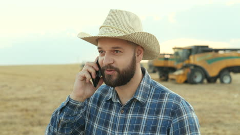 close up of farmer in a hat talking on the phone