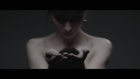 a woman dressed as mother nature holds soil in her hands